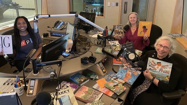 women in broadcast studio surrounded by books 