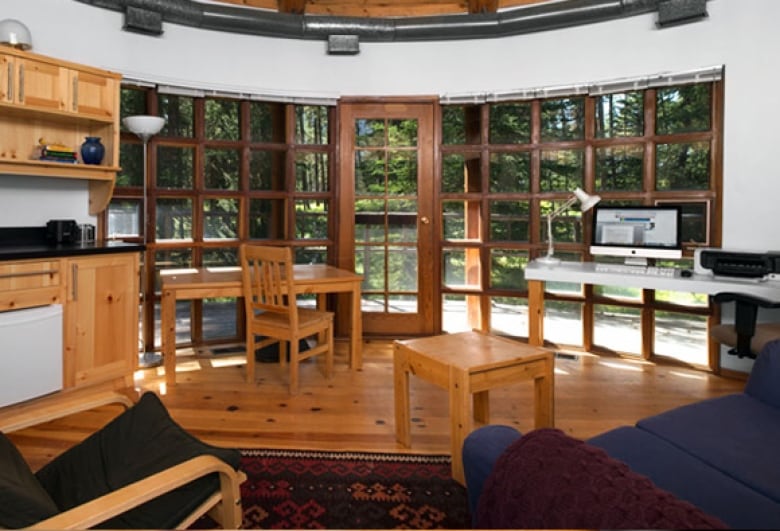 A writing space with a wooden desk in front of windows
