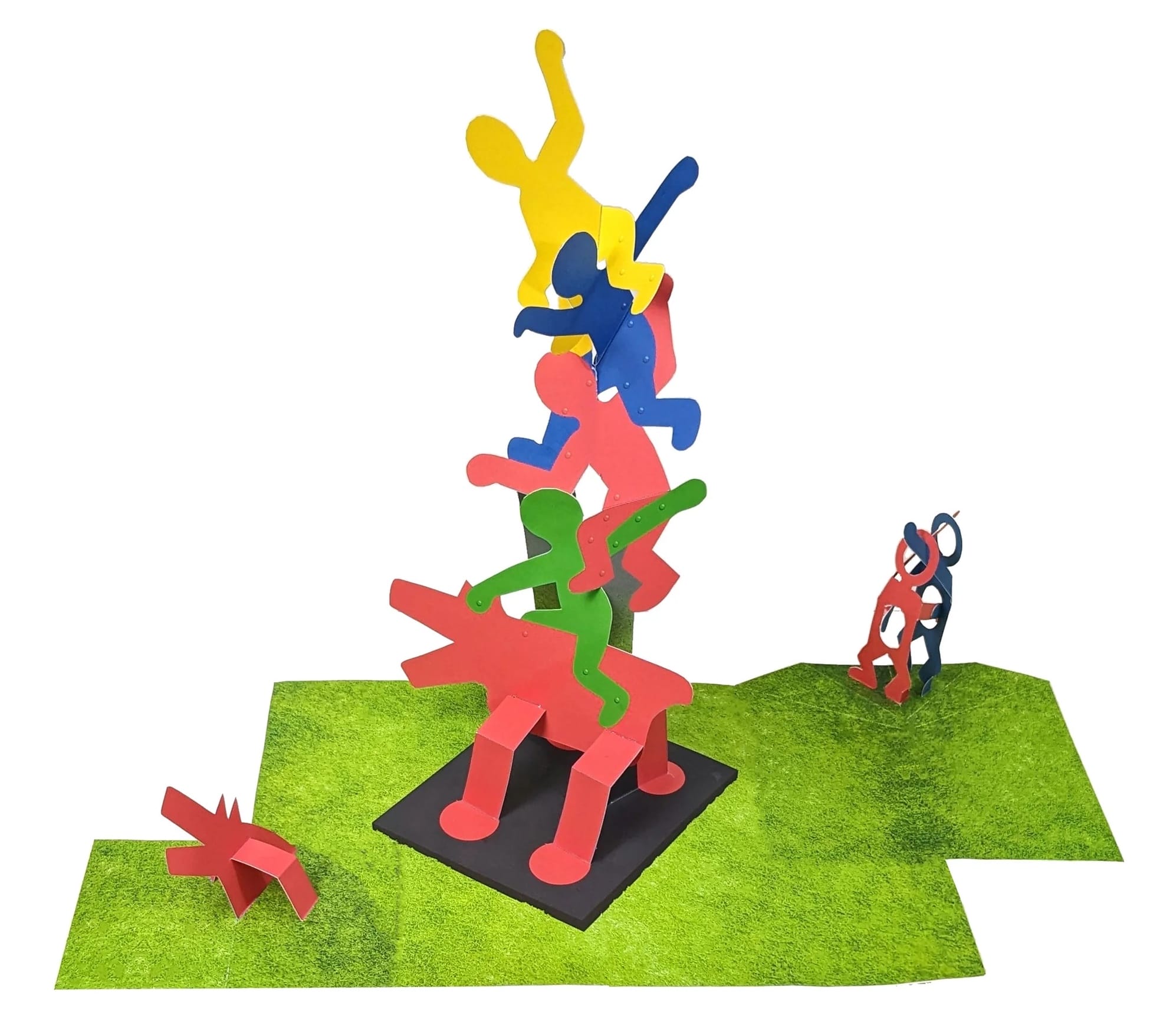 a pop-up paper spread from a pop-up book of artwork by Keith Haring, this piece depicting a stack of colorful androgynous figures on top of a red dog