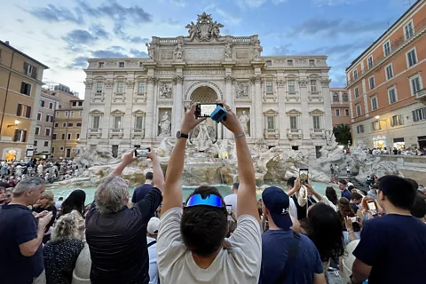 Kathleen Rellihan Tourists taking photos at the Trevi Fountain in Rome (Credit: Kathleen Rellihan)