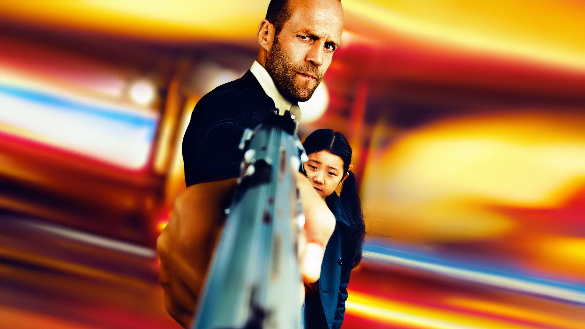 Jason Statham in Safe pointing a pistol directly at the camera with a little girl hiding behind him.